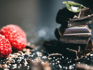 zwei himbeeren und stückchen von einer zartbitterschokoladetafel