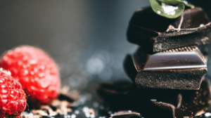 zwei himbeeren und stückchen von einer zartbitterschokoladetafel